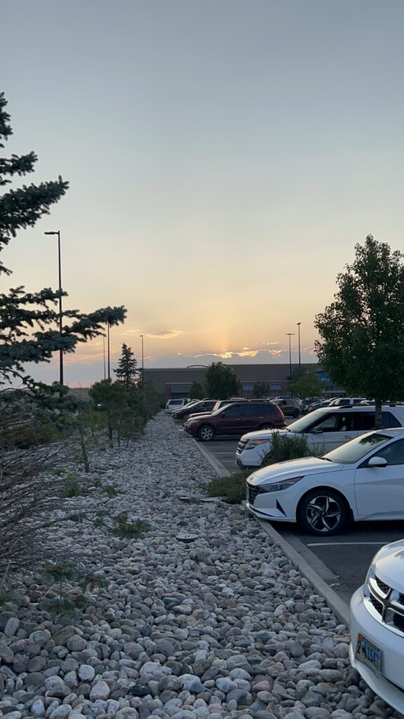 Parking lot with cars, showing a sunset