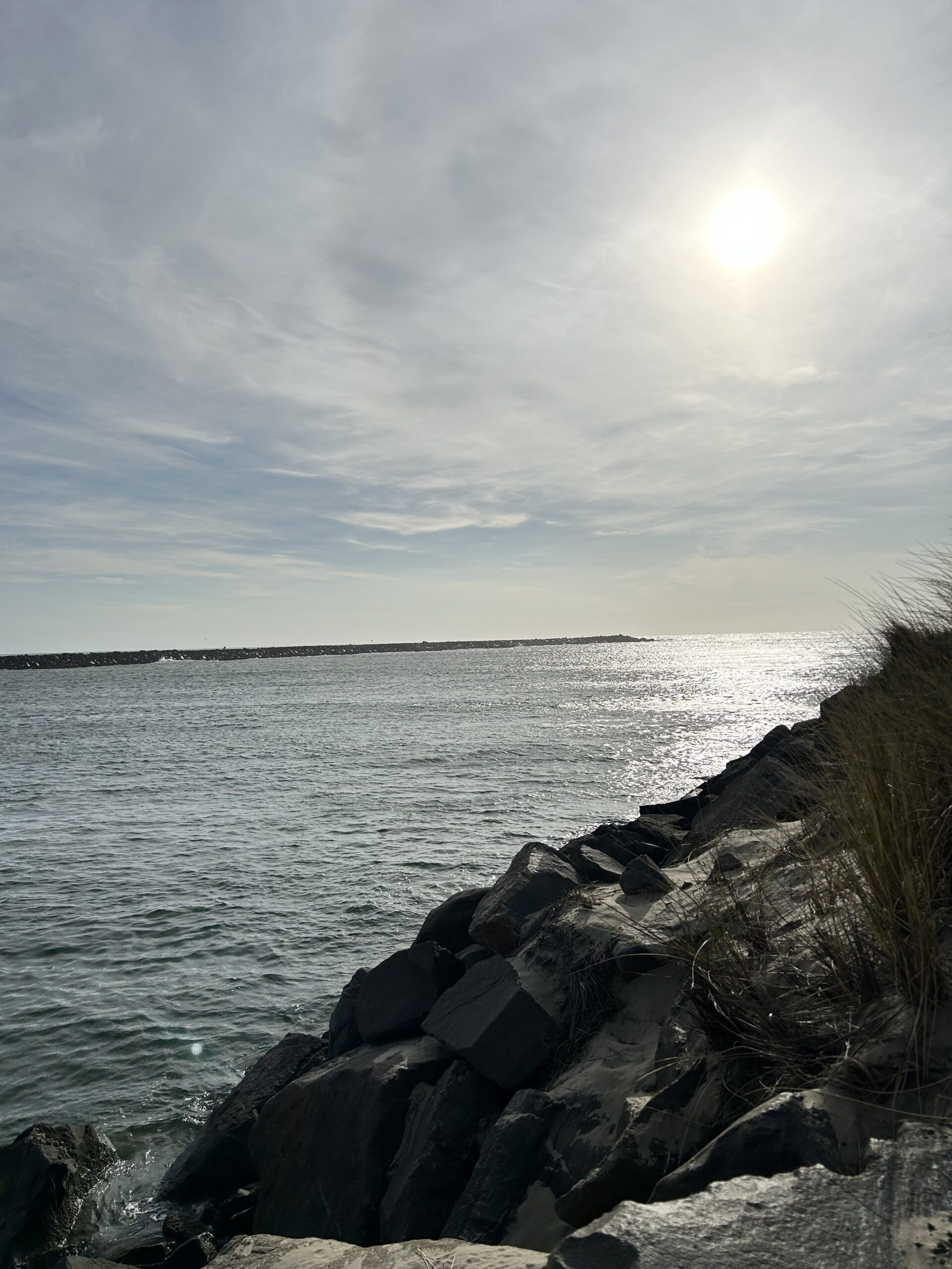 rocky hill, ocean, cloudy sky